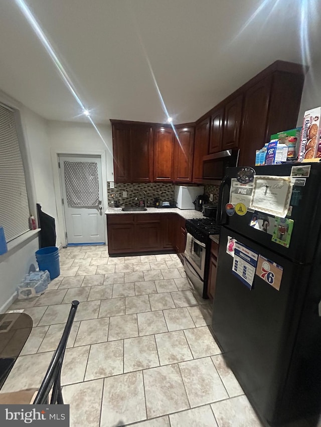 kitchen featuring stainless steel appliances, light tile patterned flooring, sink, and decorative backsplash