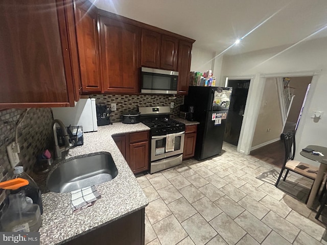 kitchen with tasteful backsplash, appliances with stainless steel finishes, and sink