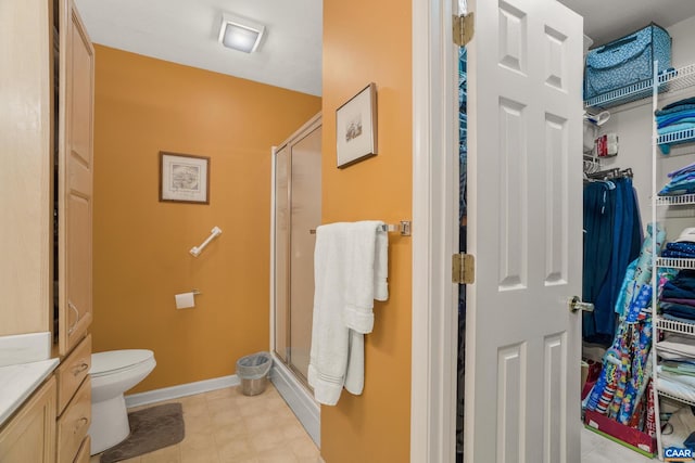 bathroom with vanity, toilet, and a shower with door