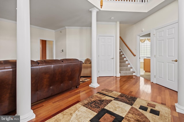 interior space featuring ornamental molding, decorative columns, and hardwood / wood-style floors