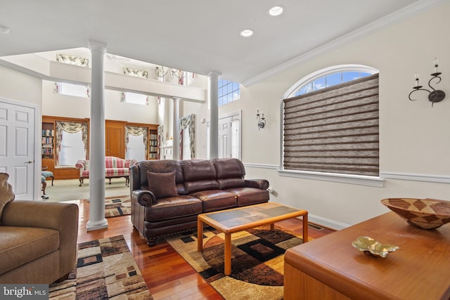 living room featuring hardwood / wood-style flooring, ornamental molding, and decorative columns