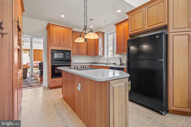 kitchen with pendant lighting, sink, black appliances, and a kitchen island