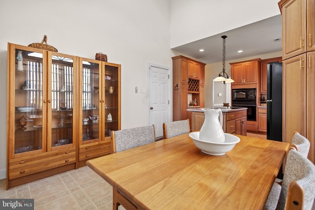 dining space featuring light tile patterned floors and a high ceiling