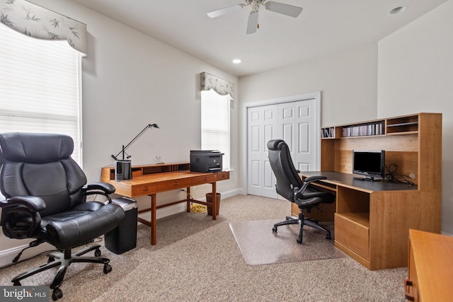 carpeted office space with ceiling fan