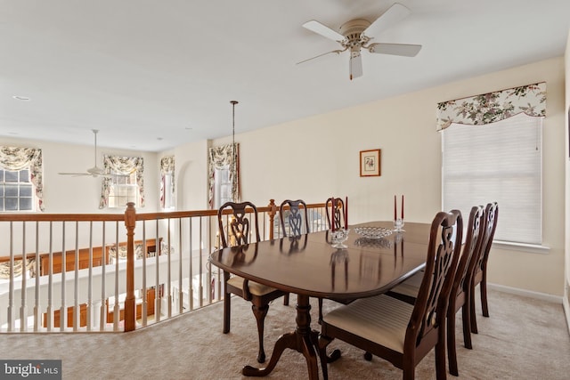 dining space featuring ceiling fan, light carpet, and a wealth of natural light