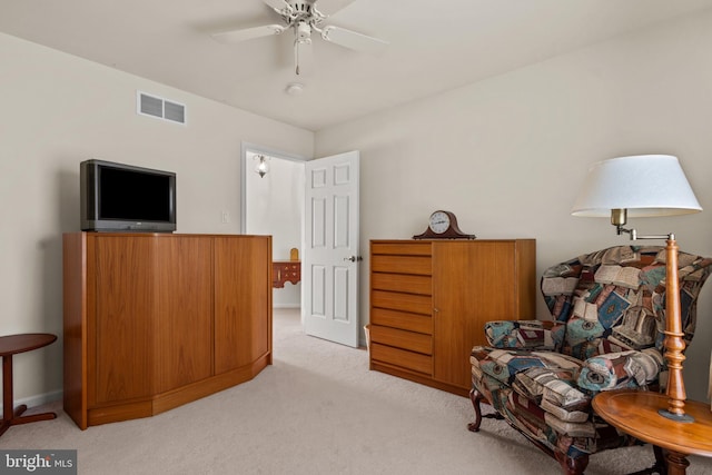 sitting room with ceiling fan and light colored carpet