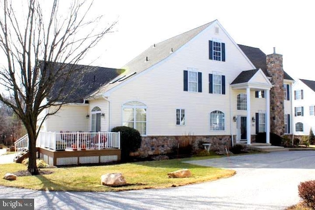 view of front of house featuring a wooden deck and a front yard