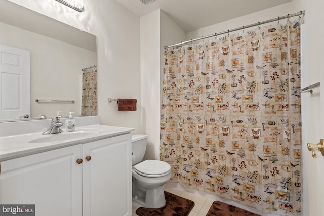 bathroom featuring toilet, vanity, tile patterned flooring, and walk in shower