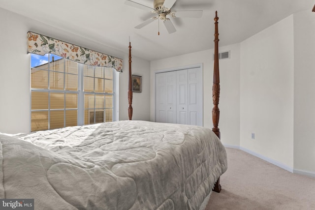 carpeted bedroom with ceiling fan and a closet