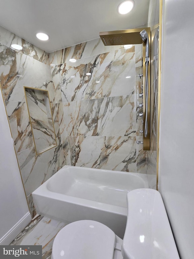 bathroom featuring tiled shower / bath and toilet