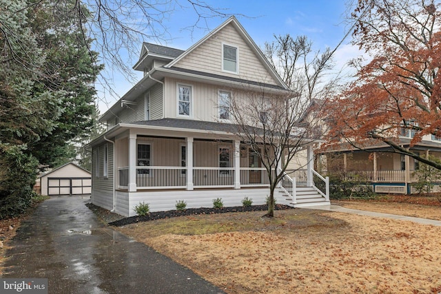 view of front of home featuring a garage, an outbuilding, and covered porch