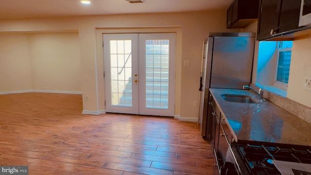 doorway to outside featuring sink, light hardwood / wood-style flooring, and french doors