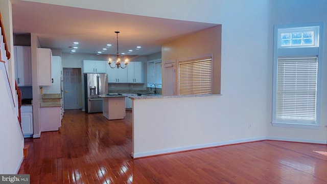 kitchen featuring sink, decorative light fixtures, stainless steel fridge with ice dispenser, a notable chandelier, and white cabinets