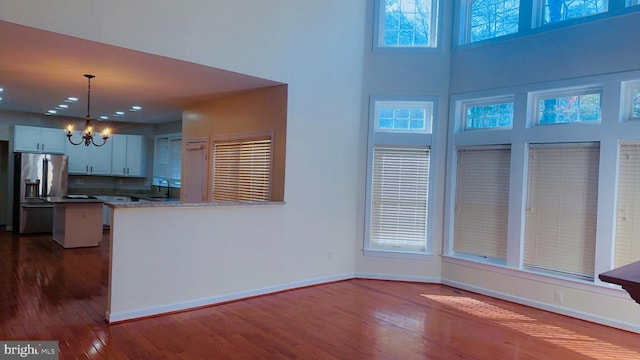 kitchen with sink, a notable chandelier, white cabinets, stainless steel fridge with ice dispenser, and decorative light fixtures