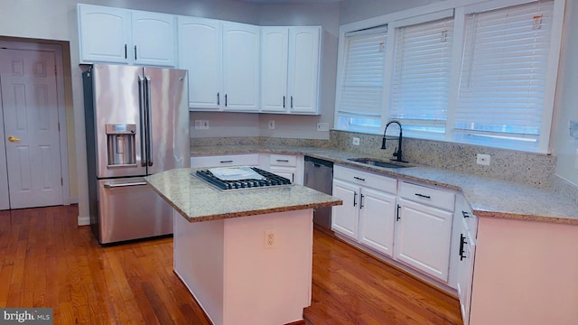 kitchen featuring appliances with stainless steel finishes, sink, a kitchen island, and white cabinets