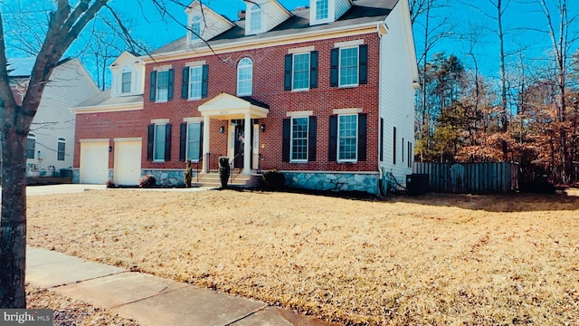 view of front facade with a garage and central air condition unit