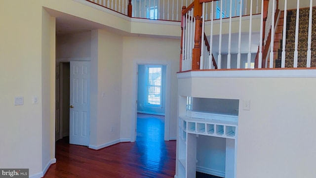 interior space with dark hardwood / wood-style floors and a high ceiling