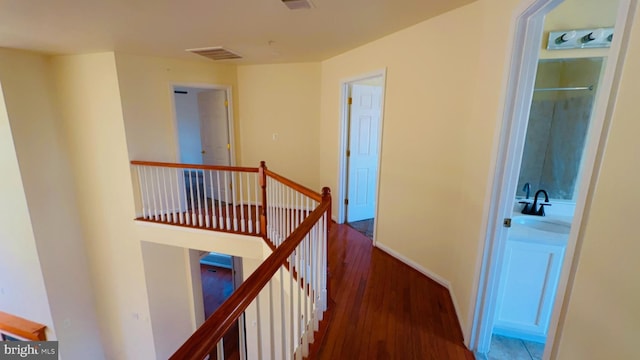 corridor featuring dark wood-type flooring and sink