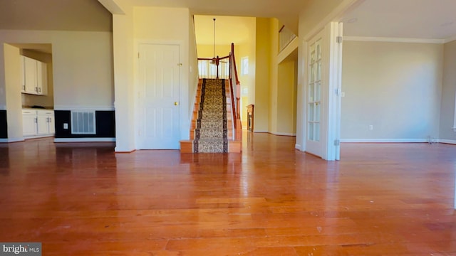 unfurnished room with wood-type flooring and ornamental molding