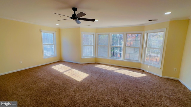 carpeted spare room featuring crown molding and ceiling fan