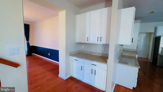 kitchen featuring white cabinetry, light stone counters, and dark hardwood / wood-style flooring