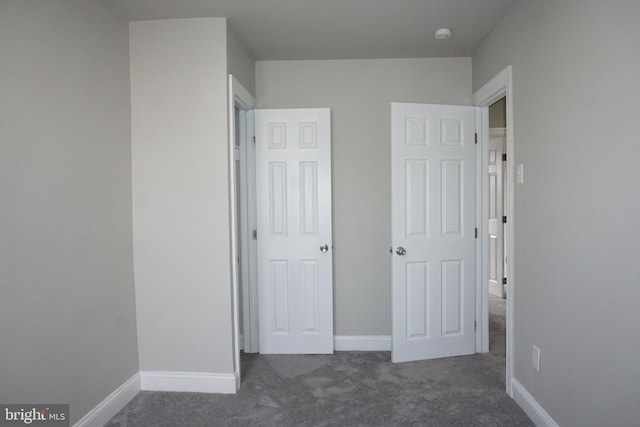 unfurnished bedroom featuring dark carpet