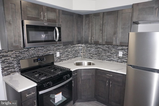 kitchen featuring stainless steel appliances, sink, dark brown cabinetry, and decorative backsplash