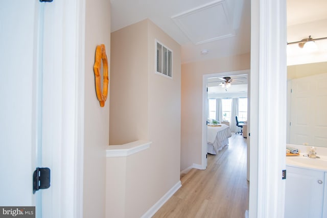 hallway with sink and light hardwood / wood-style floors