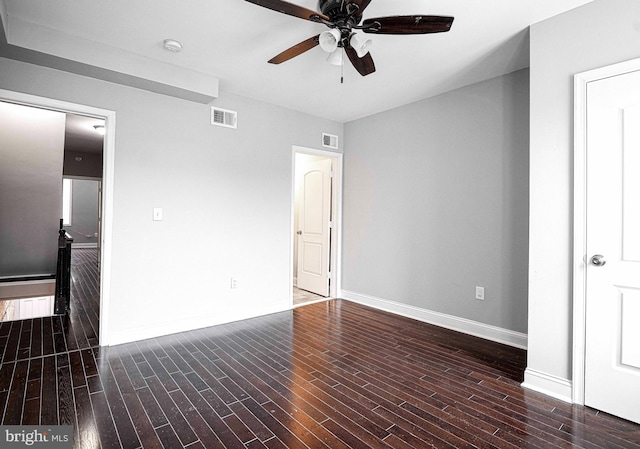 spare room featuring dark wood-type flooring and ceiling fan