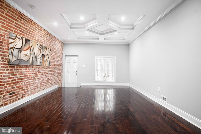 empty room featuring coffered ceiling, hardwood / wood-style flooring, ornamental molding, and brick wall