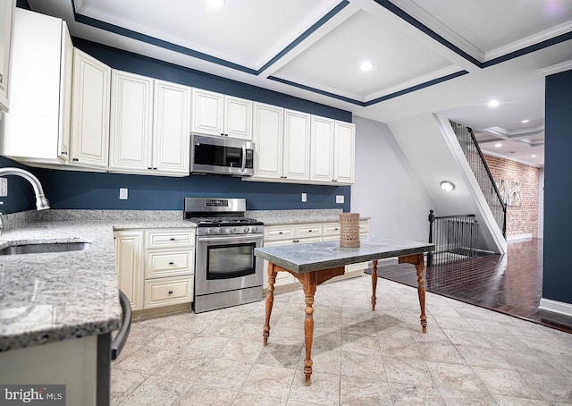 kitchen with sink, crown molding, stainless steel appliances, coffered ceiling, and light stone countertops