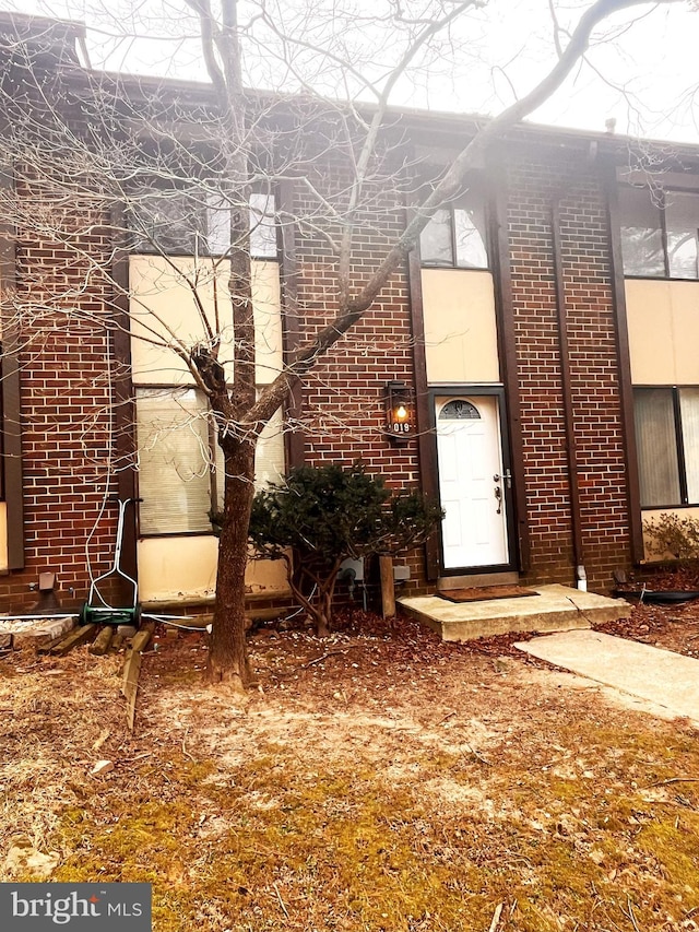 doorway to property featuring brick siding