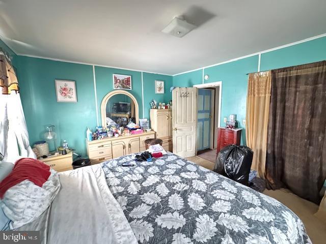 bedroom with crown molding and light colored carpet