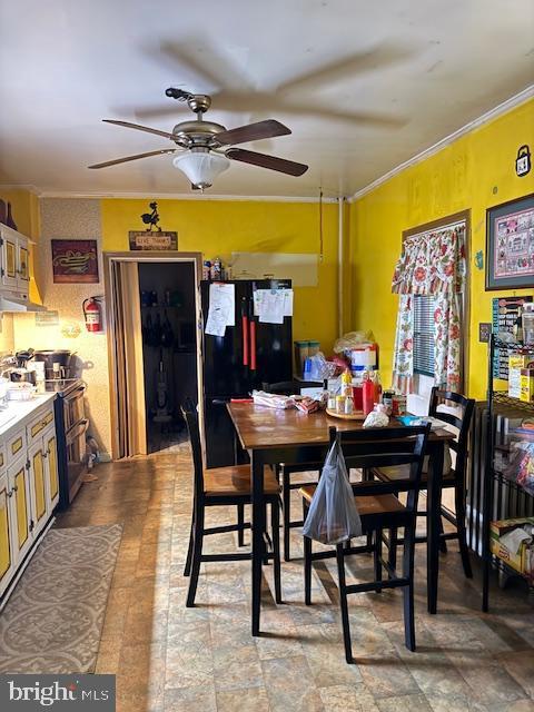 dining space with crown molding and ceiling fan