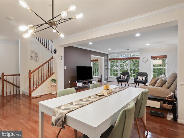 dining room featuring crown molding, wood-type flooring, and an inviting chandelier