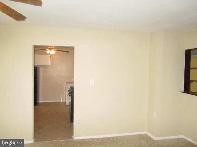 carpeted empty room featuring ceiling fan