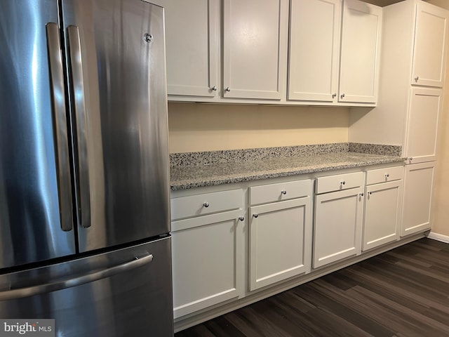8451 Greenbelt Rd Unit 102, Greenbelt, MD 20770 - kitchen featuring freestanding refrigerator, white cabinets, dark wood finished floors, and light stone countertops