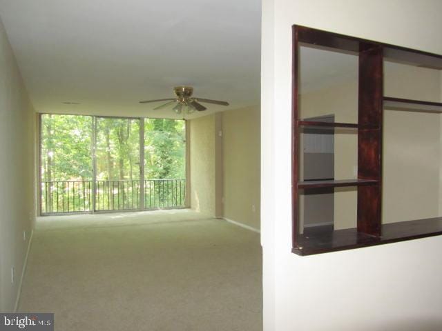 spare room with light colored carpet and ceiling fan