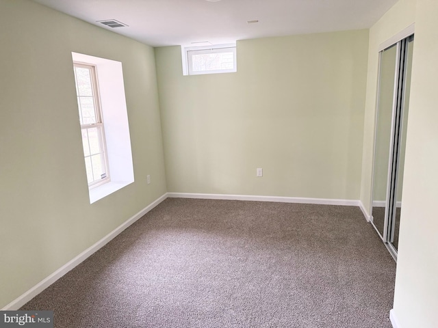 unfurnished room with visible vents, baseboards, and carpet