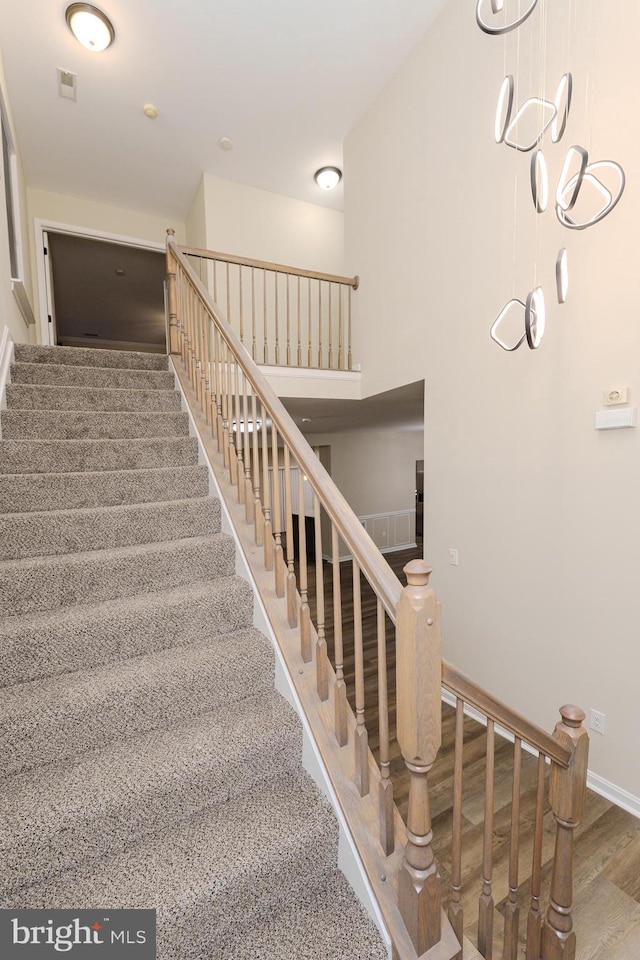 stairway featuring visible vents, wood finished floors, and baseboards