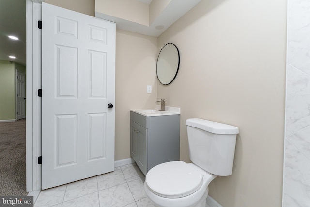 bathroom featuring baseboards, marble finish floor, vanity, and toilet