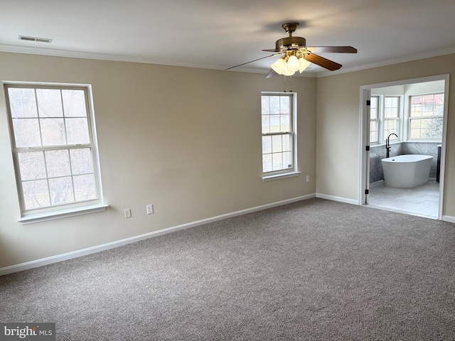 unfurnished bedroom with crown molding, ensuite bathroom, ceiling fan, and carpet flooring