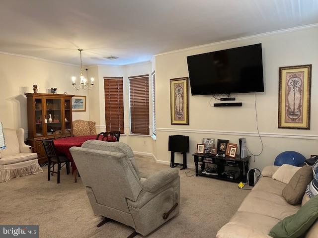 carpeted living room featuring an inviting chandelier and ornamental molding