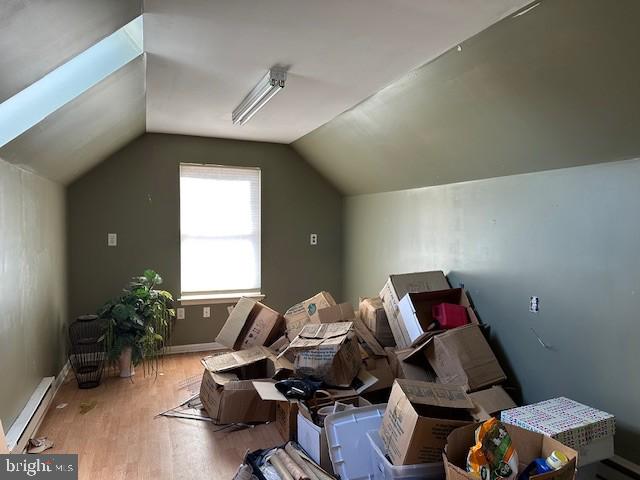 bonus room with hardwood / wood-style flooring, vaulted ceiling, and baseboard heating