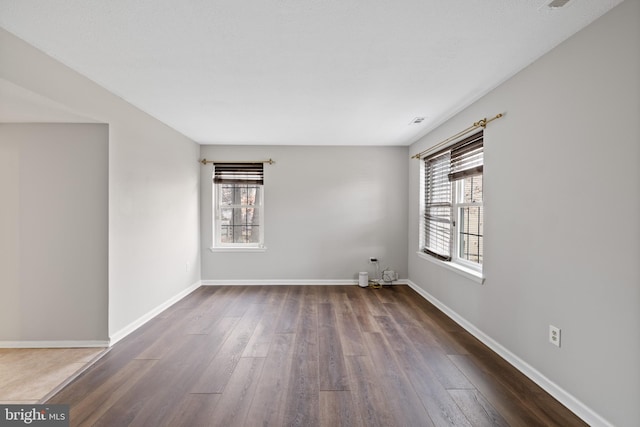 empty room with hardwood / wood-style floors and a healthy amount of sunlight