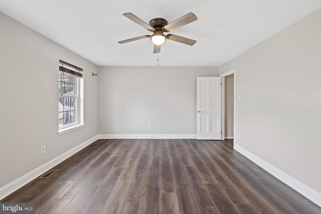 spare room featuring dark wood-type flooring and ceiling fan