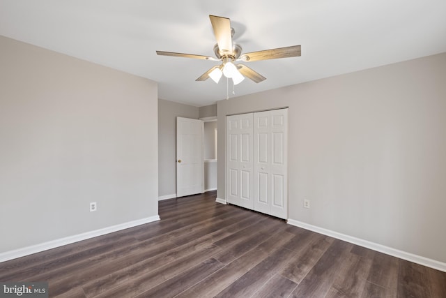 unfurnished bedroom with ceiling fan, dark hardwood / wood-style flooring, and a closet