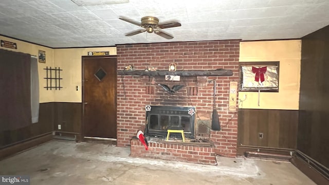 unfurnished living room featuring concrete floors, ceiling fan, and wood walls