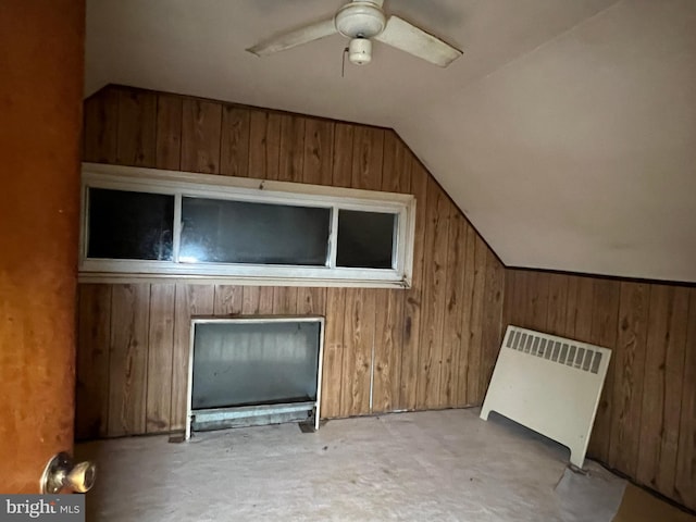 bonus room featuring lofted ceiling, radiator heating unit, wooden walls, and a fireplace