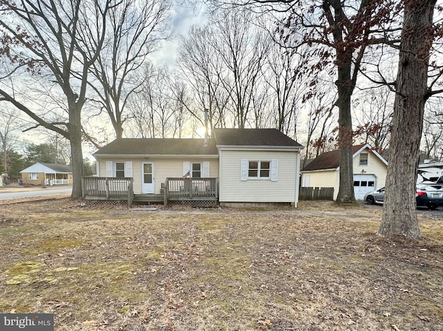 view of front facade with a garage, an outdoor structure, and a deck